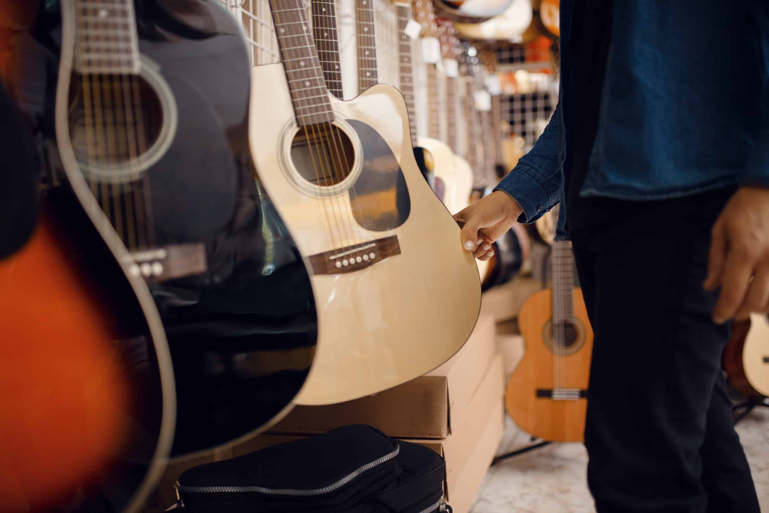 A man buying a guitar displayed at Howards Pawn & Jewelry.